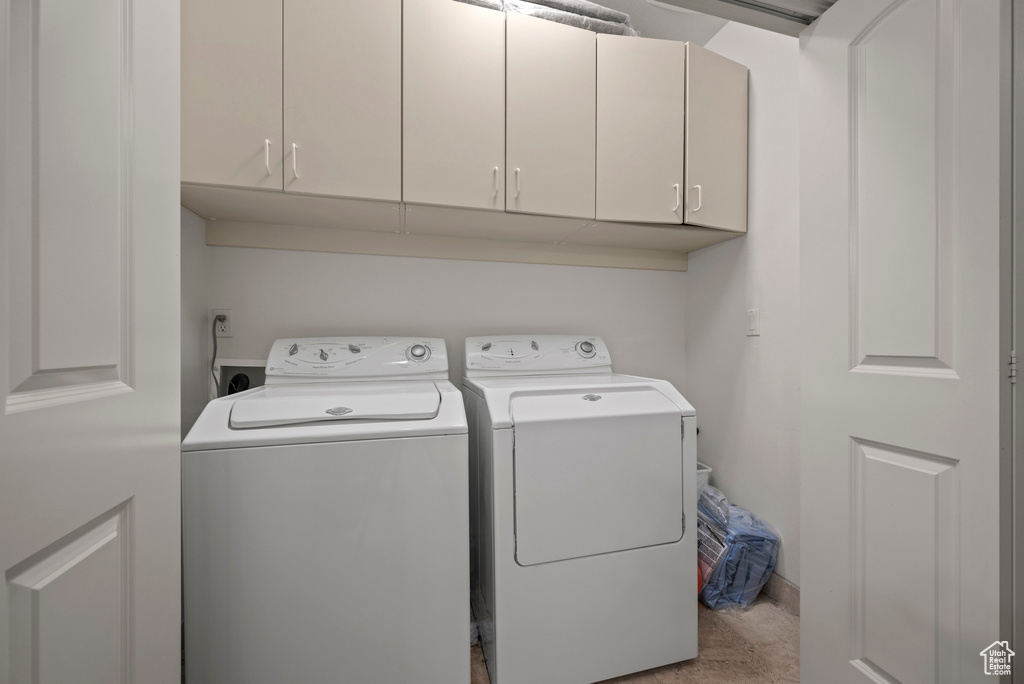 Laundry area featuring separate washer and dryer and cabinet space