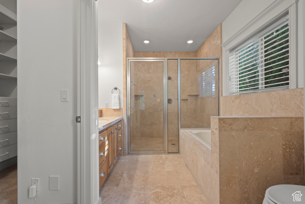Full bath featuring a stall shower, a garden tub, vanity, and recessed lighting