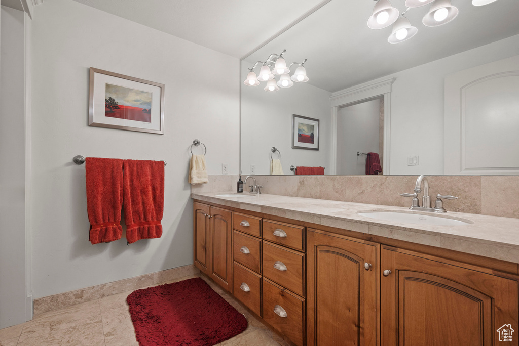 Full bathroom featuring double vanity and baseboards