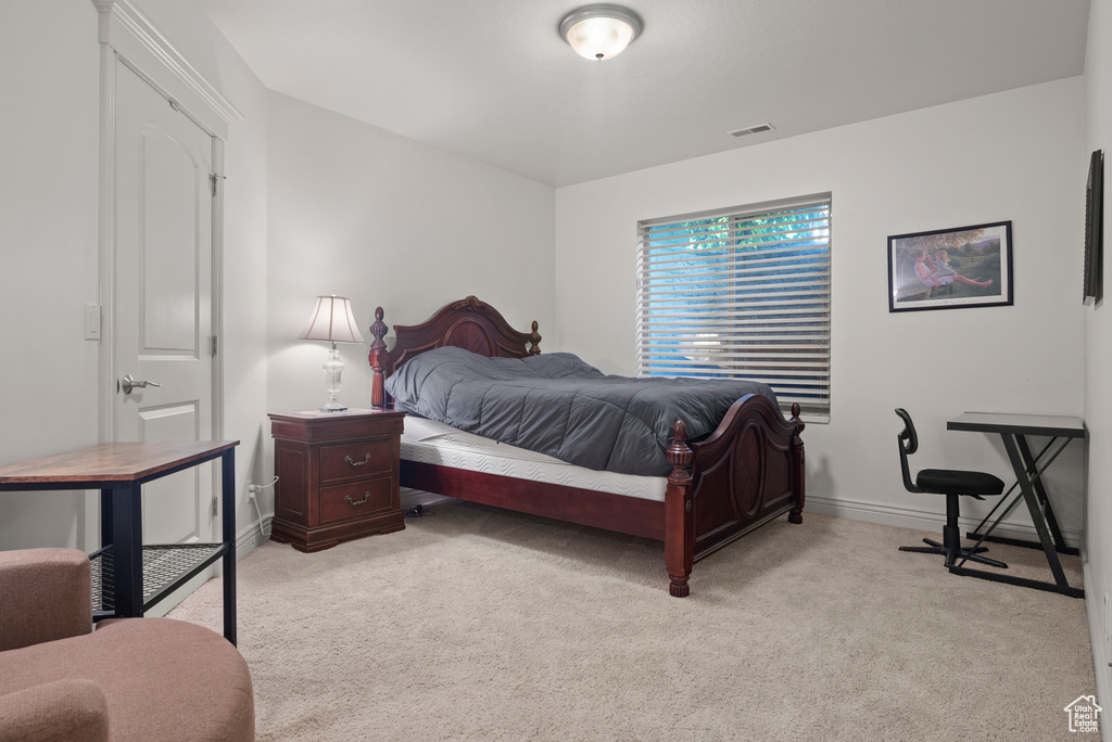 Bedroom with light colored carpet and baseboards