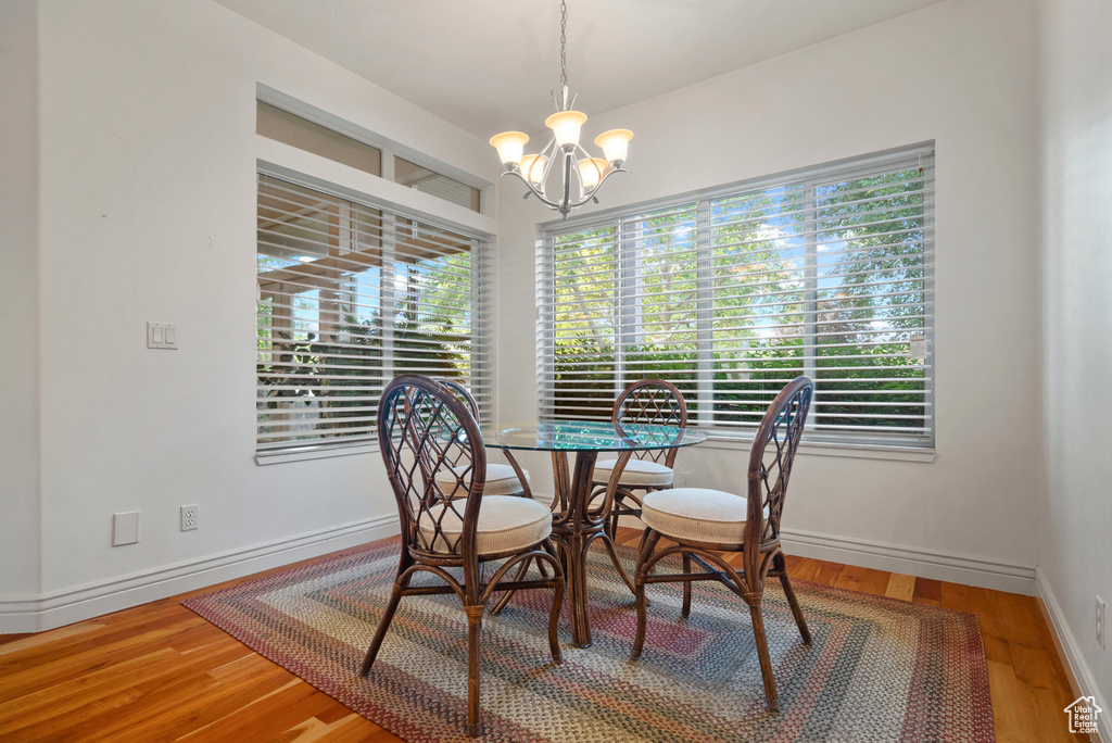 Dining space featuring a chandelier, wood finished floors, and baseboards