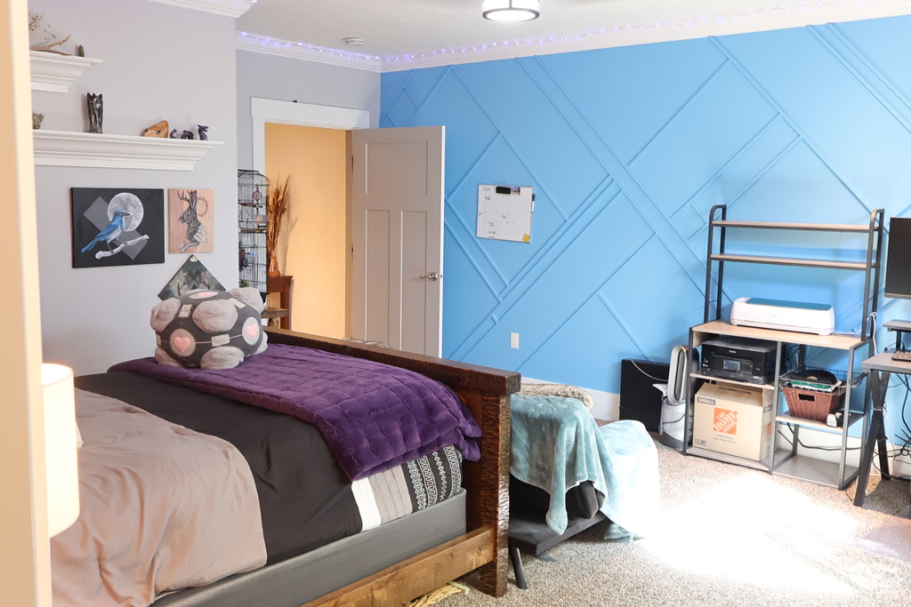 Bedroom with a decorative wall, carpet floors, and crown molding