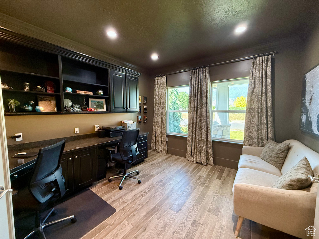 Office space with built in study area, crown molding, light wood finished floors, and recessed lighting