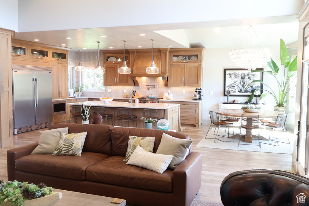 Living area with light wood-style floors, a chandelier, and recessed lighting