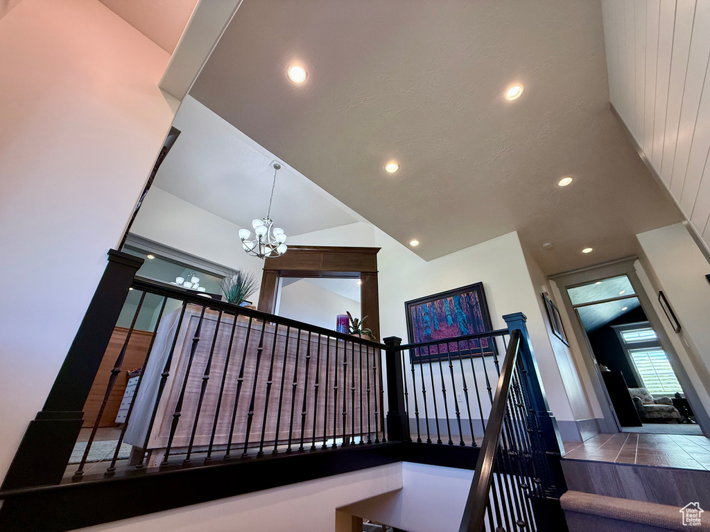 Staircase with a chandelier, recessed lighting, and high vaulted ceiling