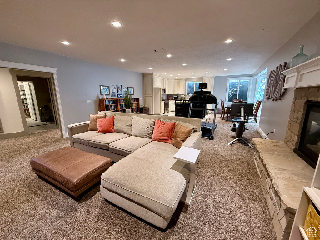 Living area with light colored carpet, a fireplace, recessed lighting, and baseboards