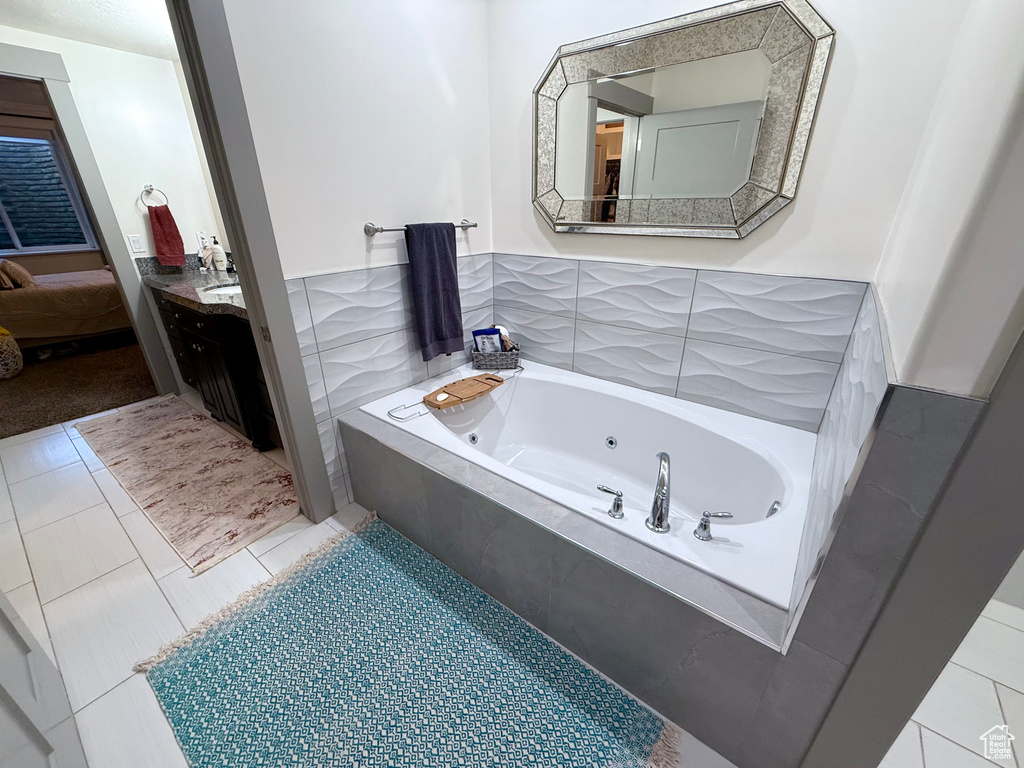 Bathroom featuring a tub with jets, vanity, and ensuite bath