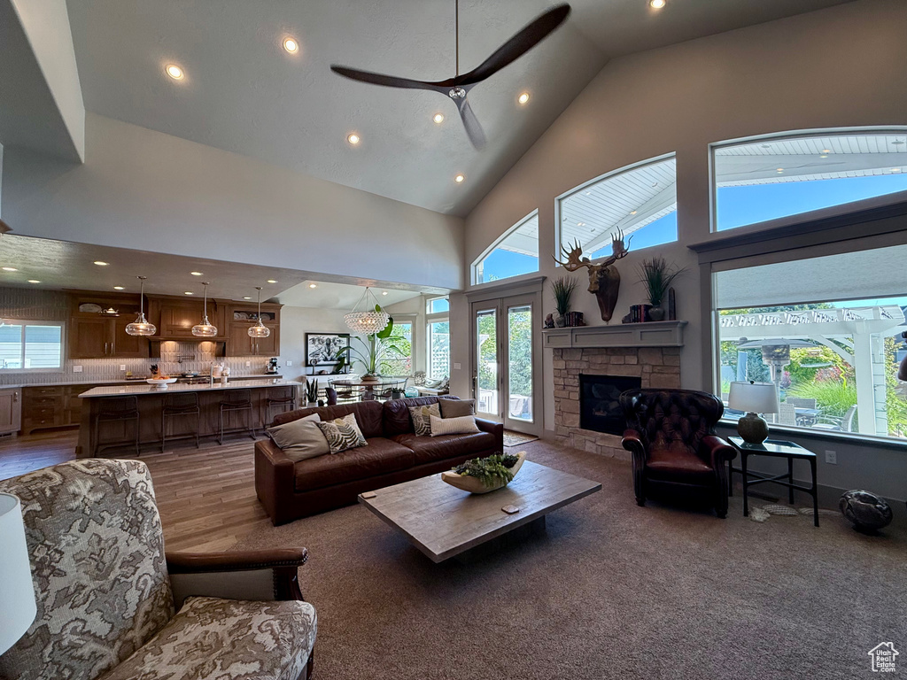 Living area featuring recessed lighting, high vaulted ceiling, a ceiling fan, healthy amount of natural light, and a fireplace