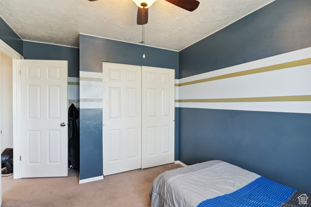 Bedroom with carpet, a closet, ceiling fan, and baseboards