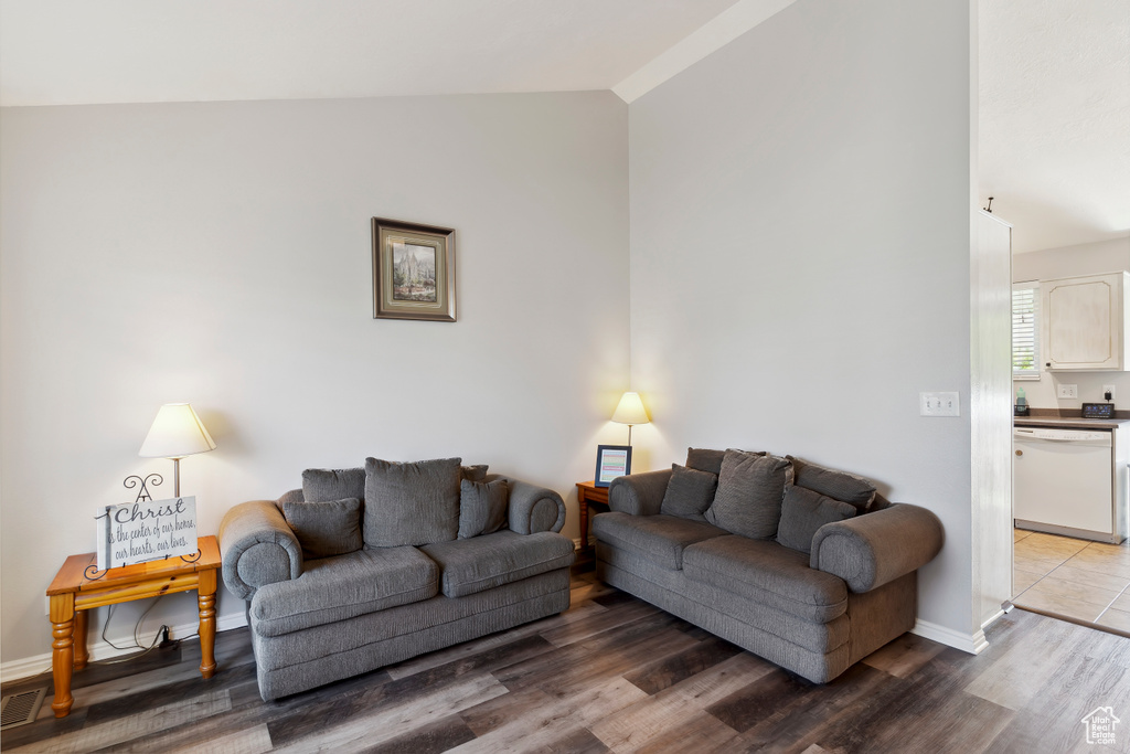 Living room featuring lofted ceiling, wood finished floors, and baseboards