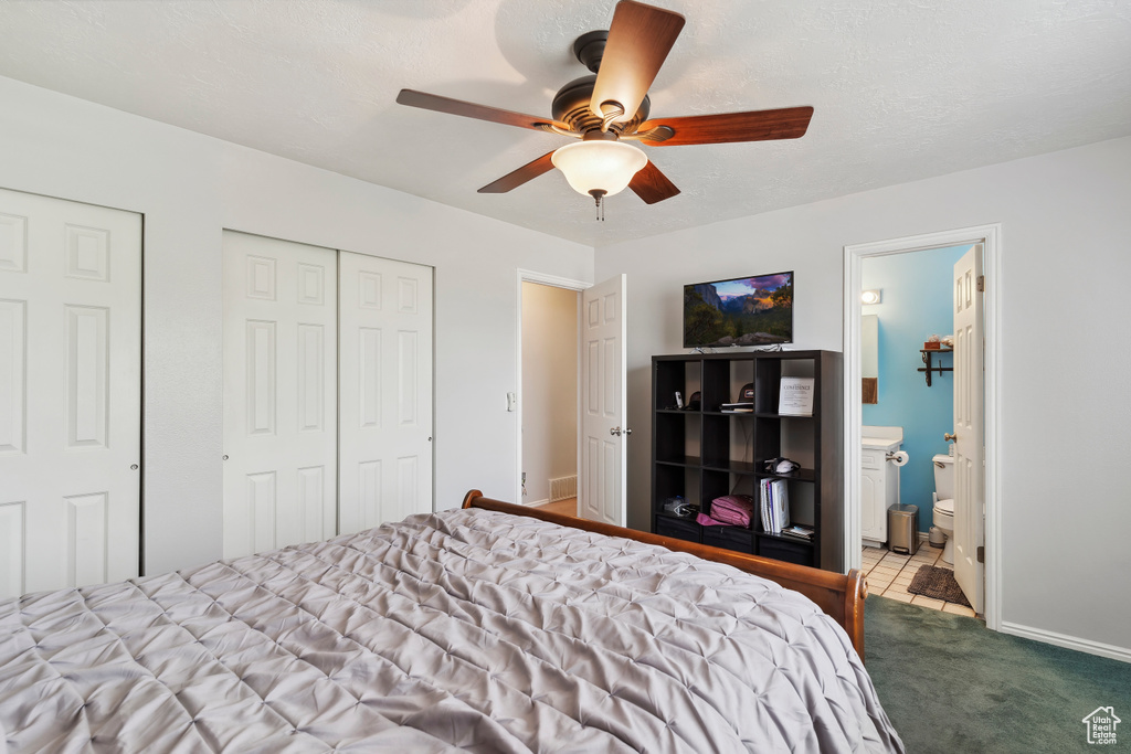 Bedroom with carpet floors, a ceiling fan, ensuite bathroom, and baseboards