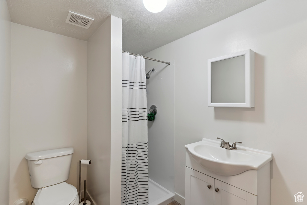 Full bathroom with vanity, a stall shower, and toilet