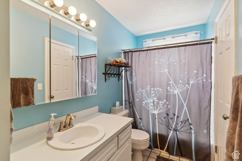 Full bathroom featuring vanity, toilet, and tile patterned floors