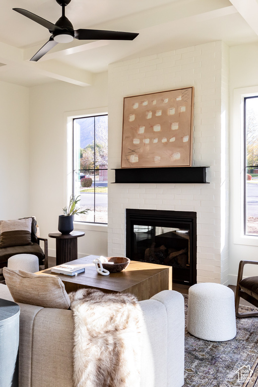 Living room with a fireplace, a ceiling fan, and plenty of natural light