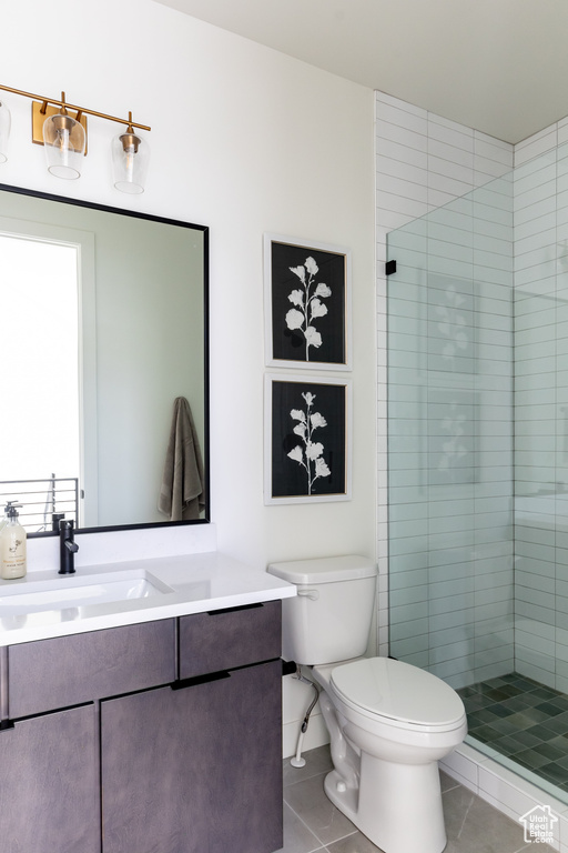 Full bath featuring tile patterned flooring, vanity, toilet, and a stall shower