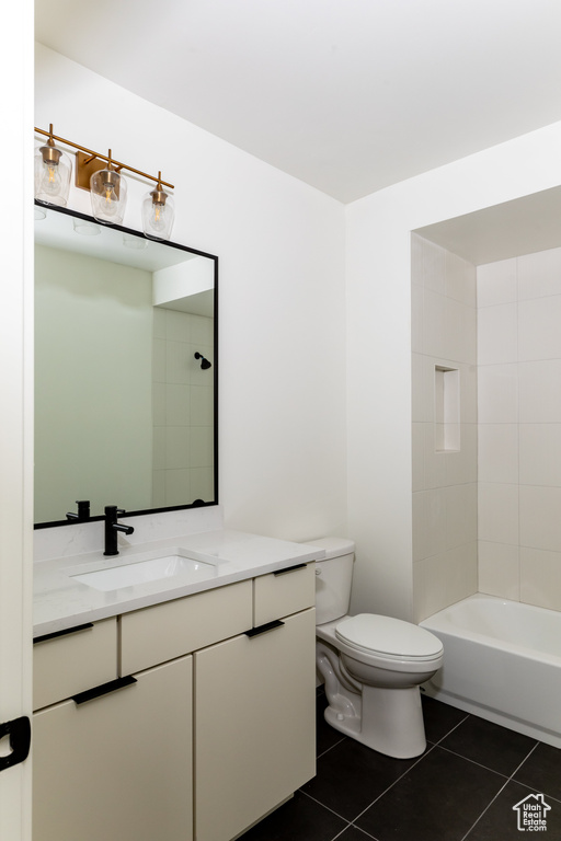 Full bath with toilet, vanity, and tile patterned flooring