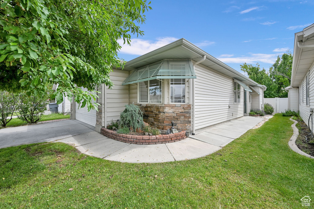 View of property exterior featuring concrete driveway, a garage, and stone siding