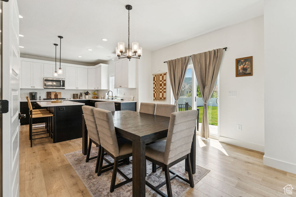 Dining area featuring a chandelier, recessed lighting, light wood-type flooring, and baseboards
