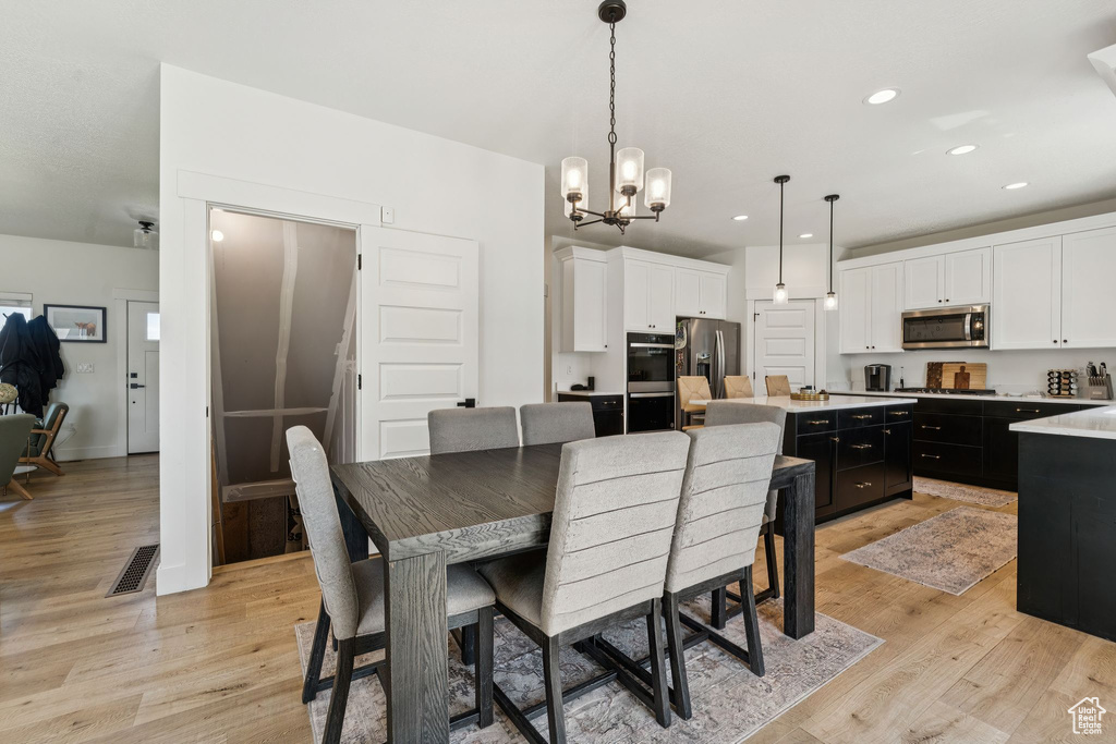 Dining space featuring light wood-style floors, a chandelier, and recessed lighting