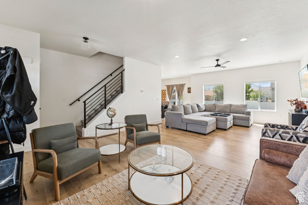 Living area with stairway, wood finished floors, a ceiling fan, recessed lighting, and baseboards