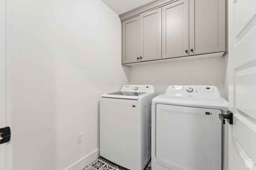 Laundry room with cabinet space, washing machine and dryer, and baseboards