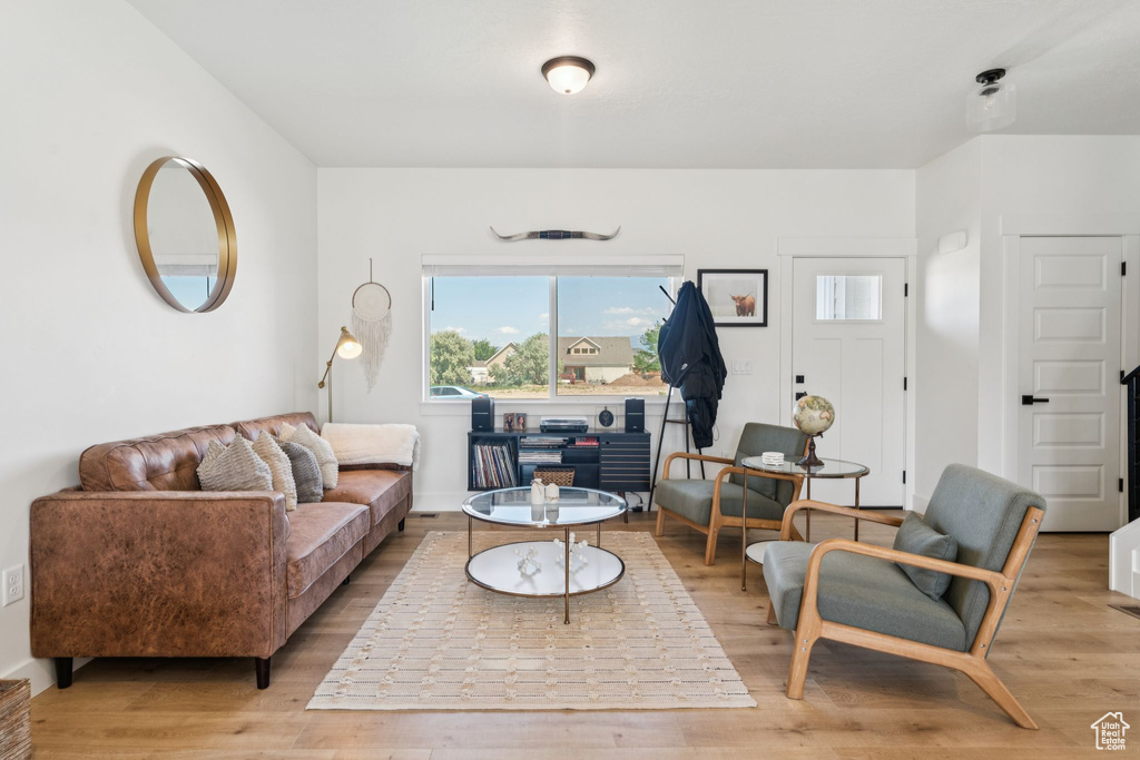 Living area featuring plenty of natural light, light wood-style flooring, and baseboards