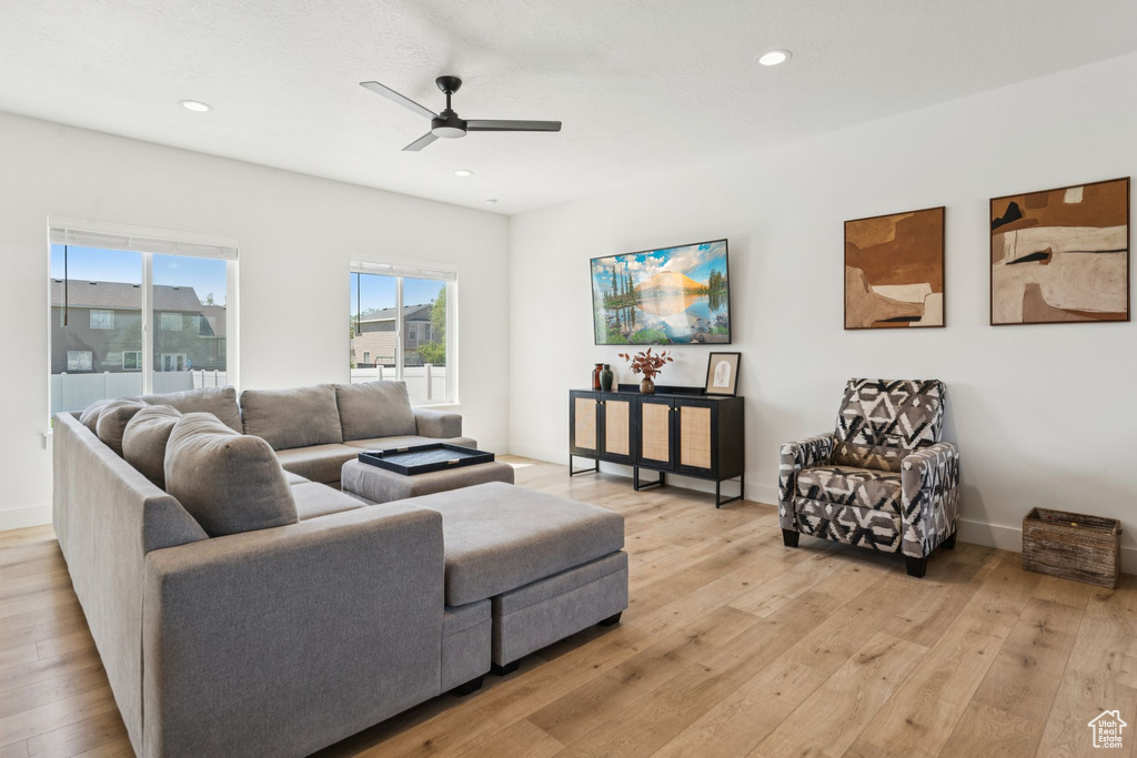 Living room featuring a ceiling fan, light wood finished floors, recessed lighting, and baseboards