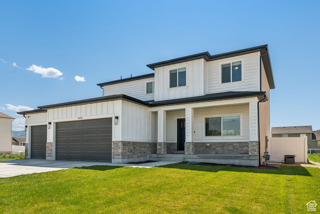 View of front facade featuring board and batten siding, a garage, driveway, stone siding, and a porch