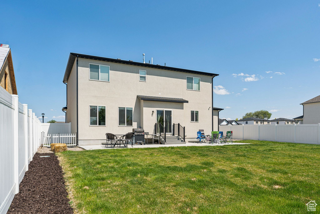 Rear view of house with a patio area, entry steps, and stucco siding