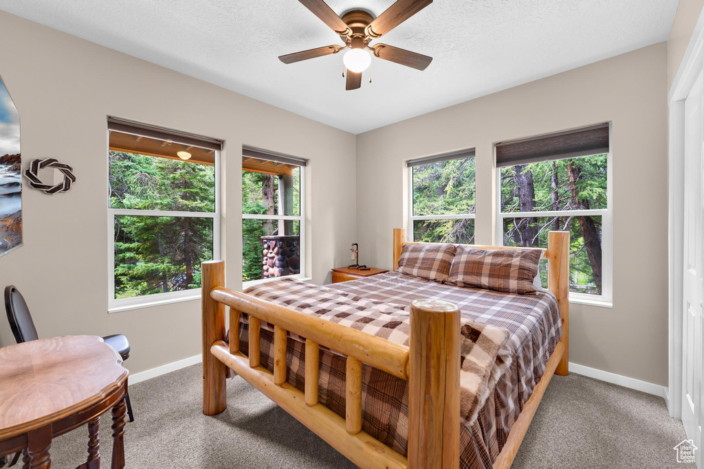 Bedroom with baseboards, light carpet, and a ceiling fan