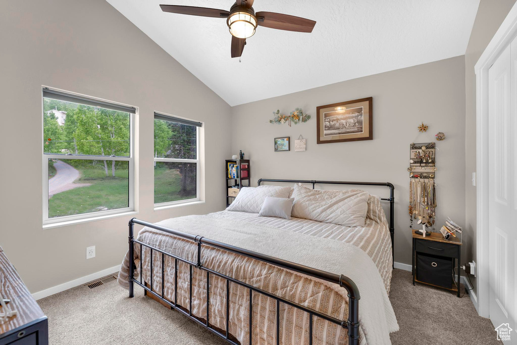 Bedroom featuring lofted ceiling, carpet floors, baseboards, and ceiling fan