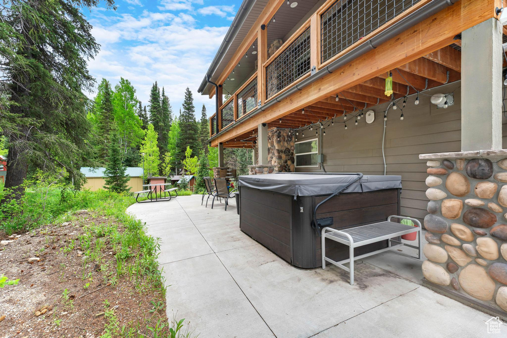View of patio / terrace featuring a hot tub, a balcony, and outdoor dining area