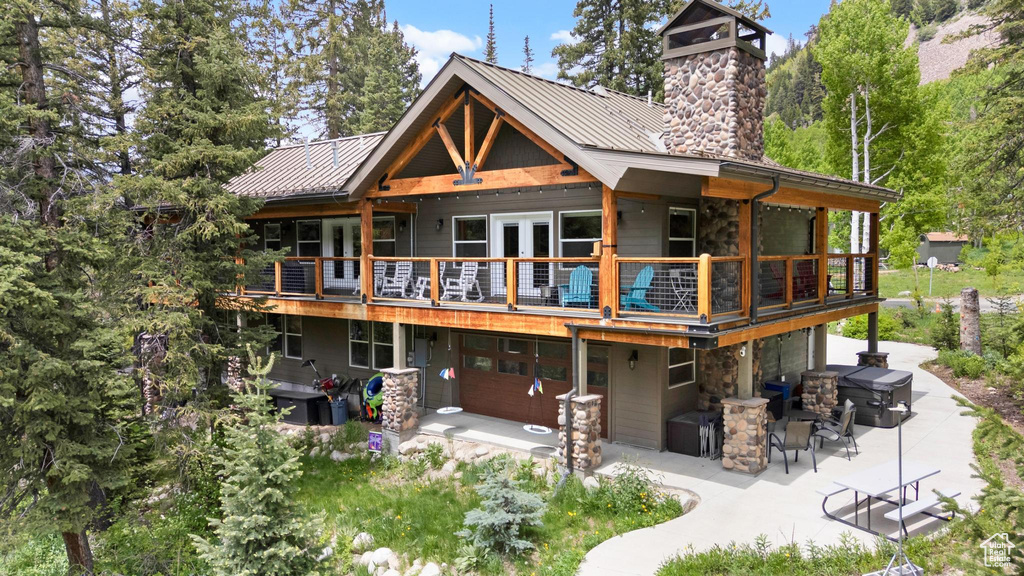 Rear view of house featuring a patio, a standing seam roof, and metal roof