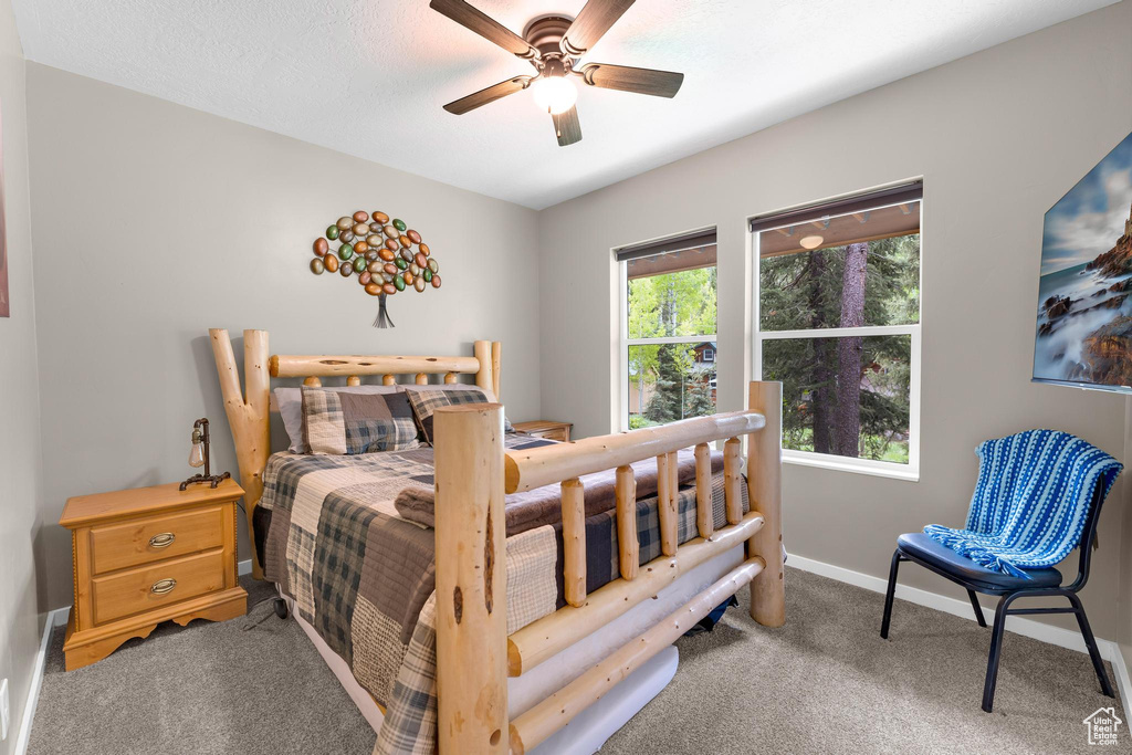 Carpeted bedroom featuring baseboards and ceiling fan