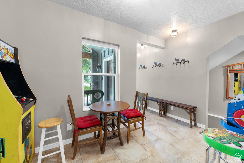 Dining room featuring a textured ceiling and baseboards