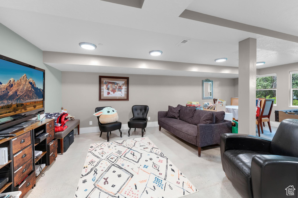 Living room featuring concrete floors, baseboards, and recessed lighting