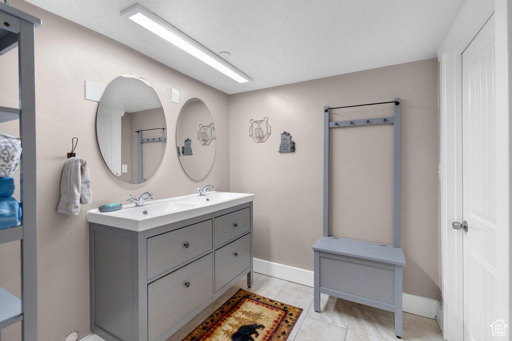 Bathroom featuring double vanity and baseboards