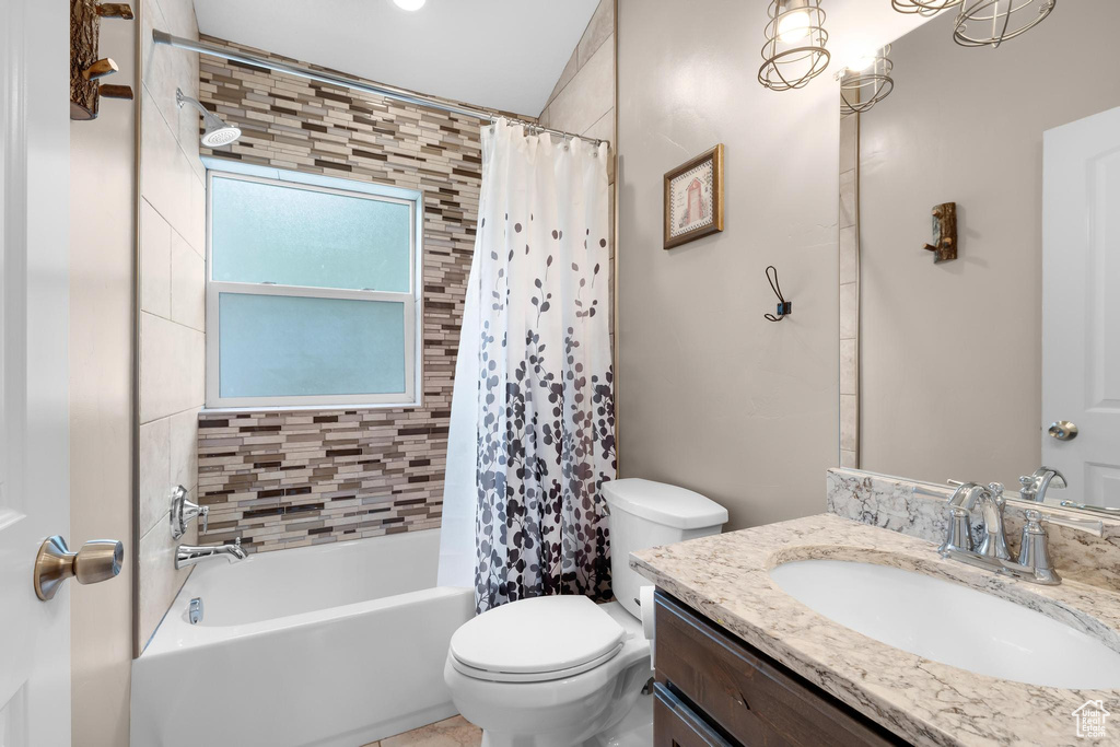 Bathroom with vanity, toilet, and shower / bathtub combination with curtain