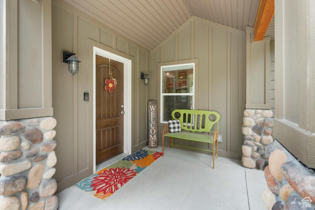 Entrance to property featuring board and batten siding and covered porch