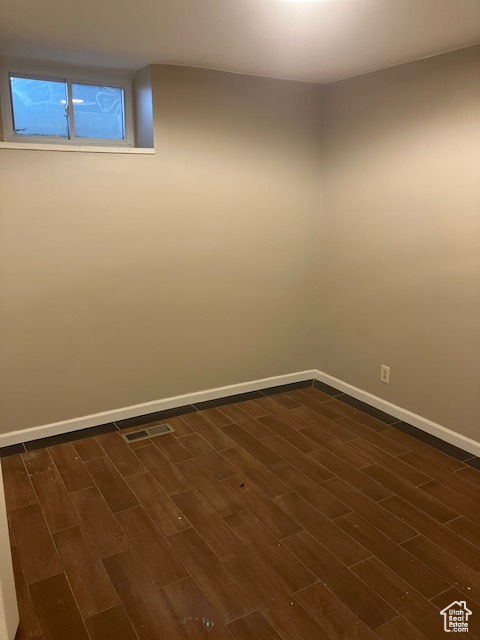 Empty room with dark wood-style floors and baseboards