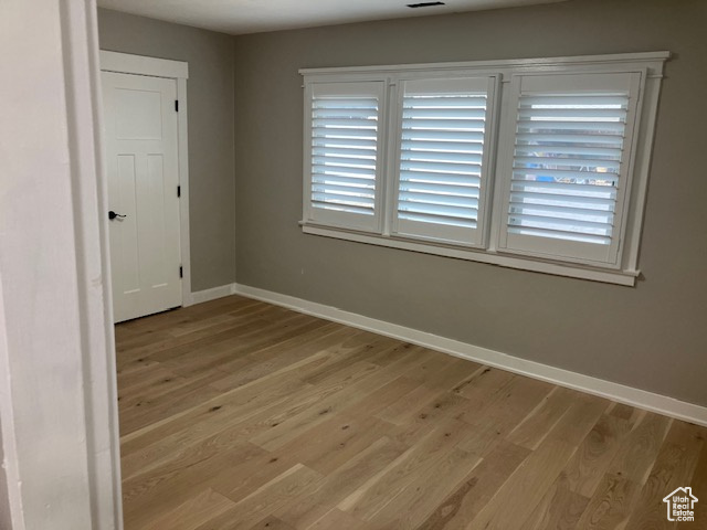 Unfurnished room with light wood finished floors and baseboards