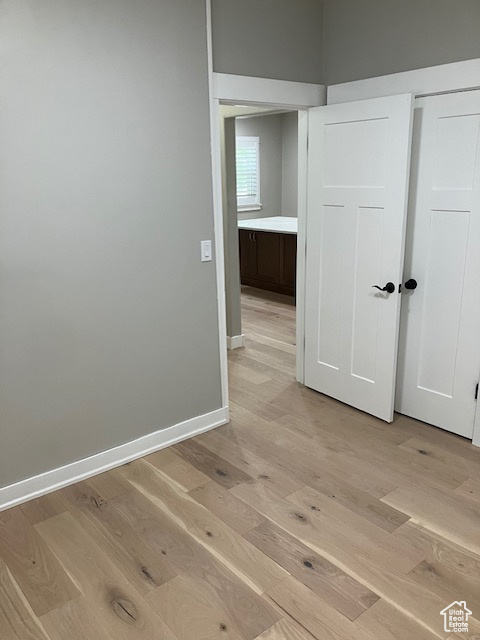 Hall with light wood-style flooring and baseboards
