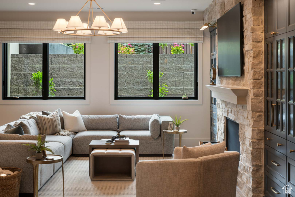 Living room featuring a chandelier, recessed lighting, and a stone fireplace