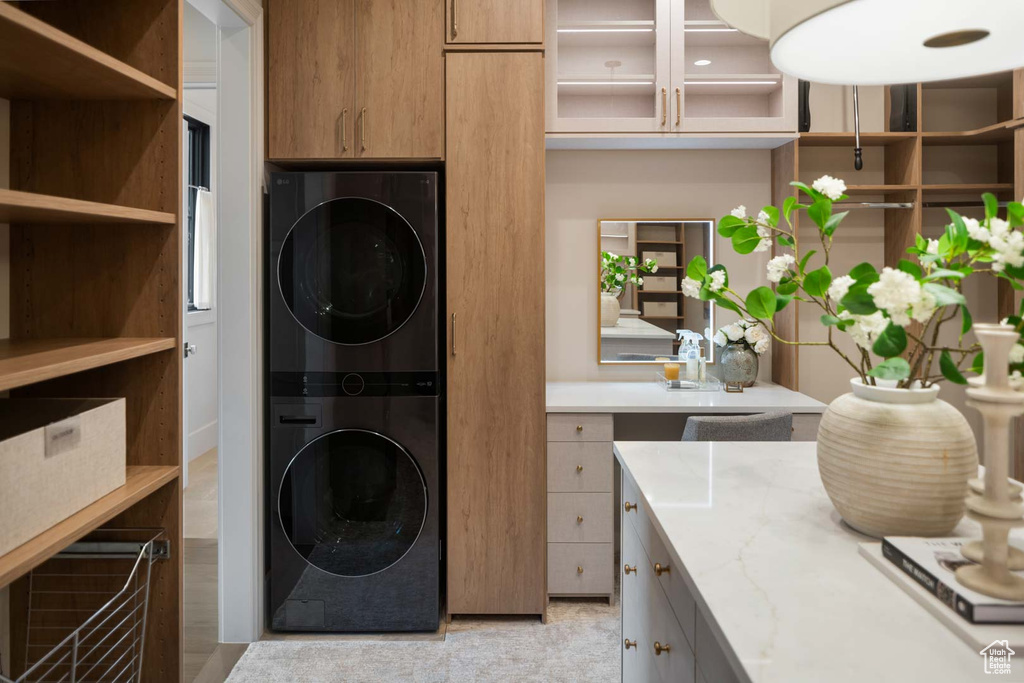 Laundry room featuring estacked washer and dryer and cabinet space