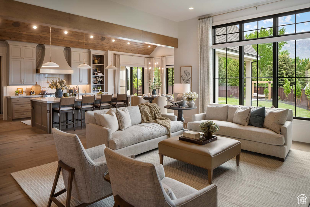 Living room with light wood-style flooring, plenty of natural light, recessed lighting, and lofted ceiling