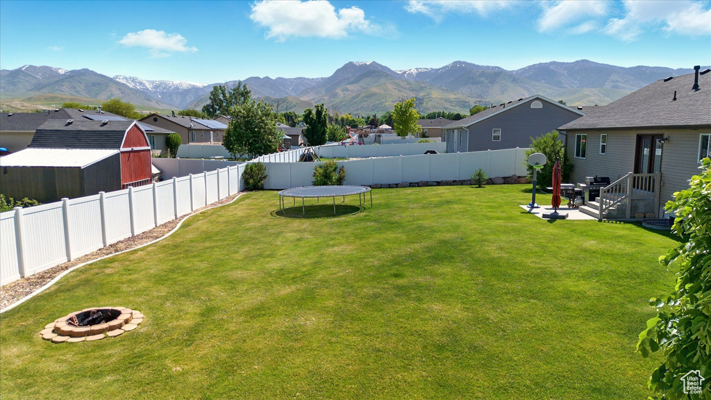 View of yard with an outdoor fire pit, a mountain view, and a residential view