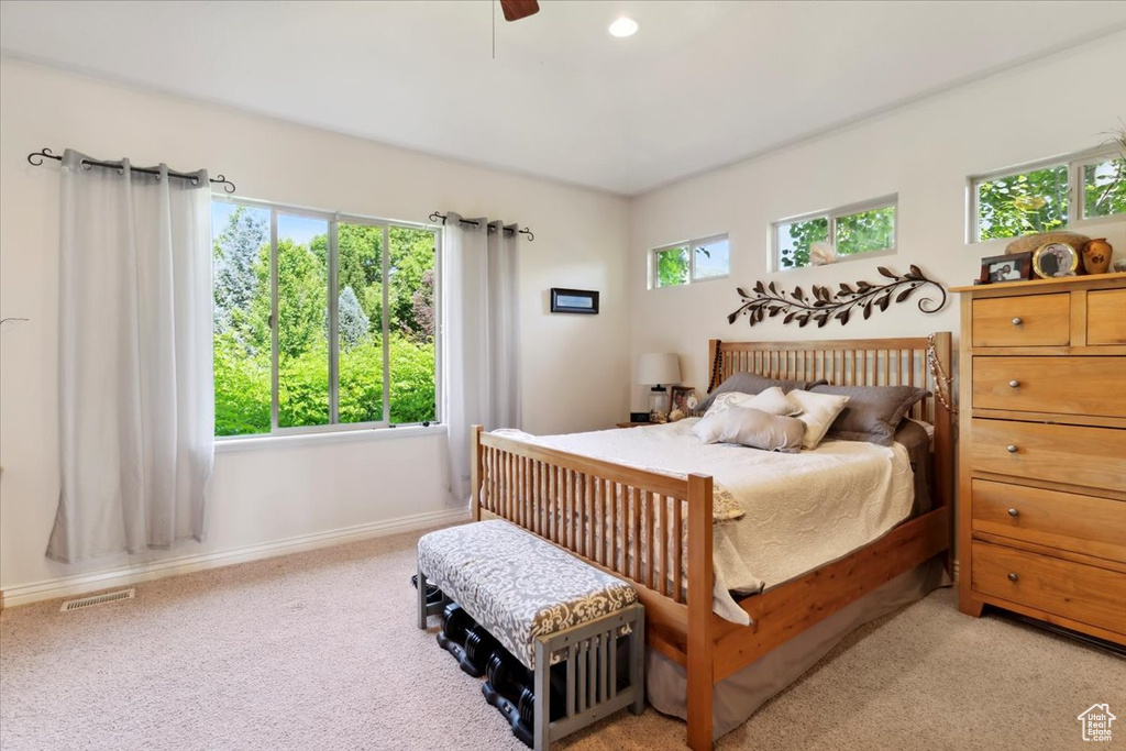 Bedroom featuring light colored carpet, baseboards, and ceiling fan