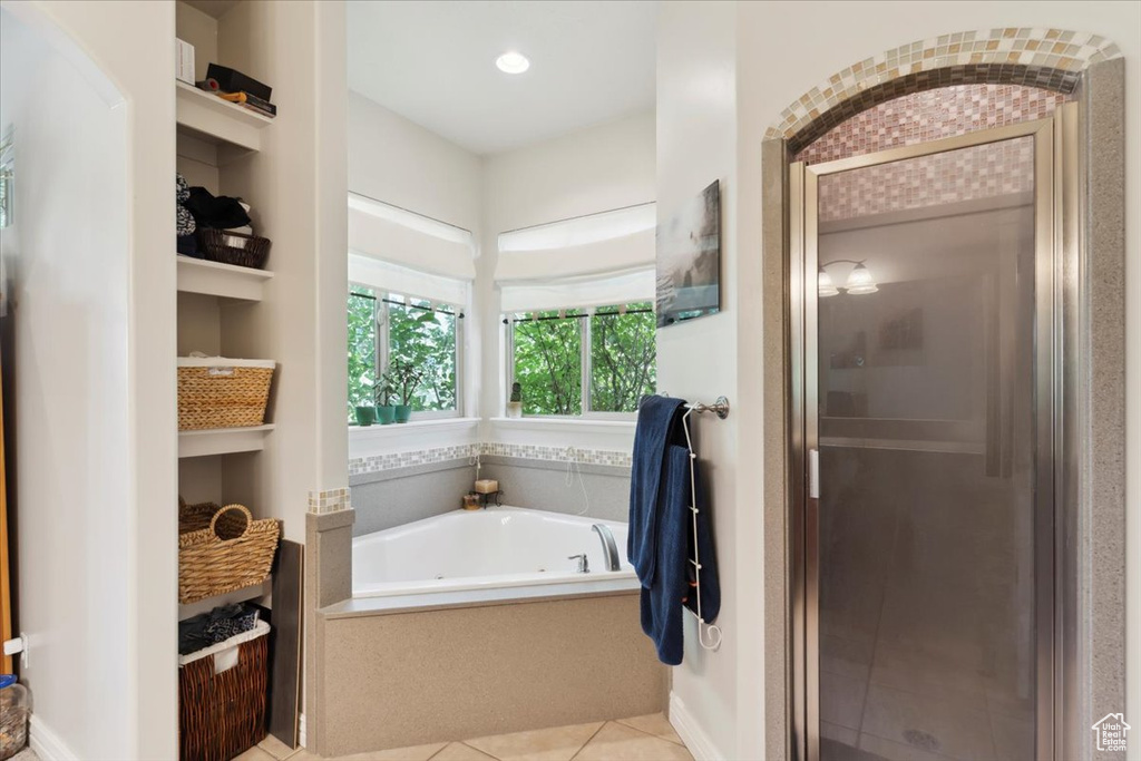 Bathroom featuring a garden tub, a stall shower, tile patterned floors, and built in features