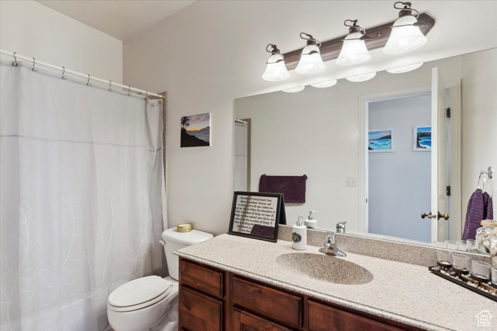 Full bath featuring vanity, toilet, and a shower with shower curtain