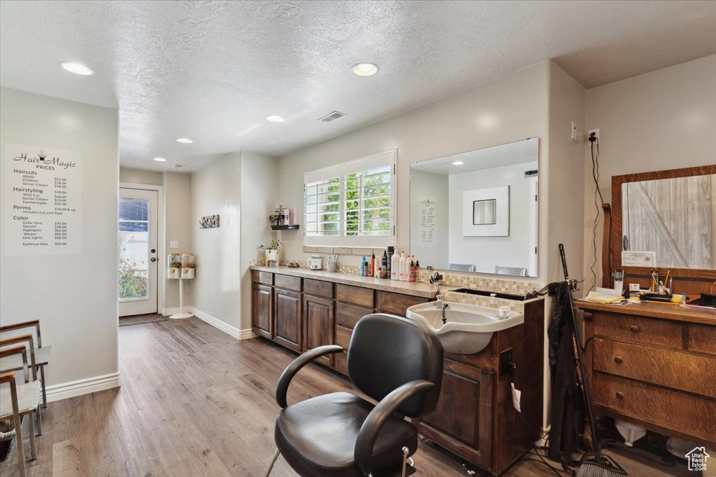 Office featuring wood finished floors, a sink, recessed lighting, a textured ceiling, and baseboards
